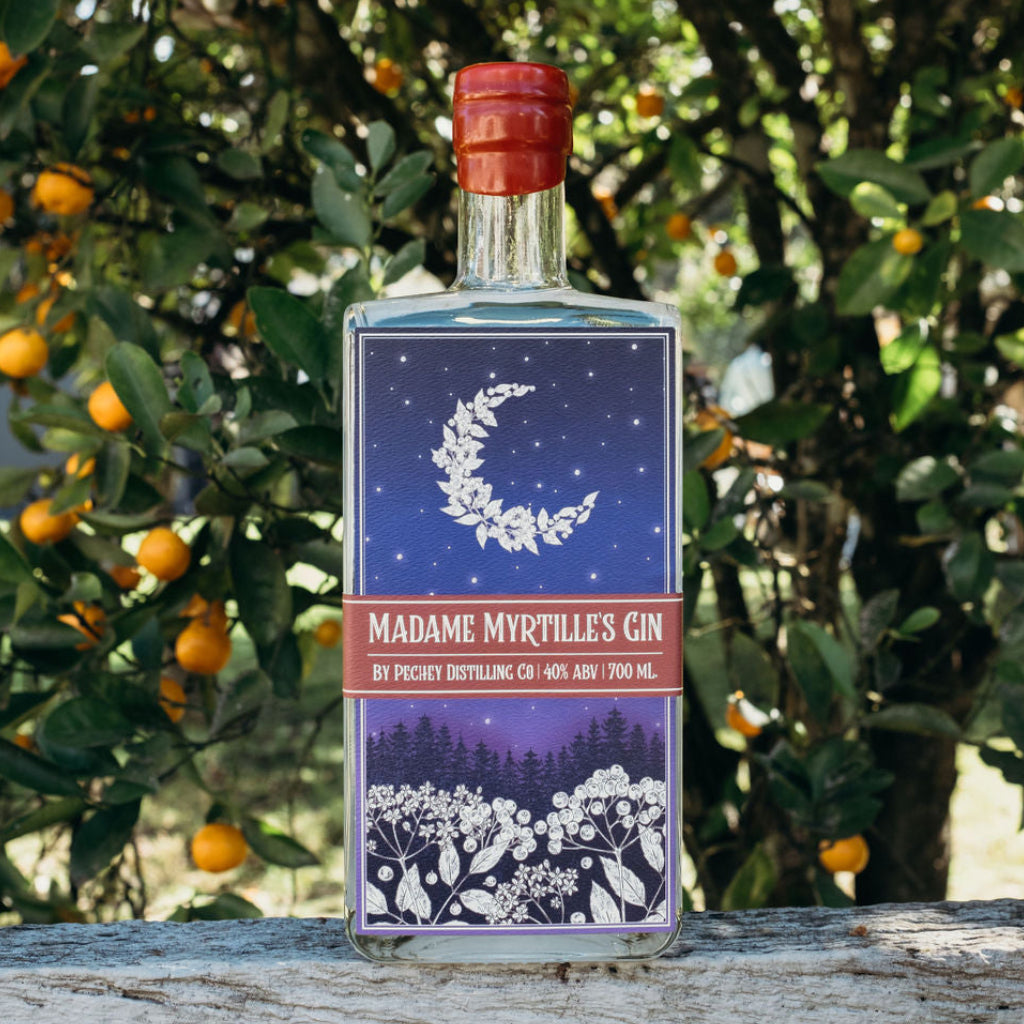 Bottle of Madame Myrtle's Gin with a decorative label against a natural background